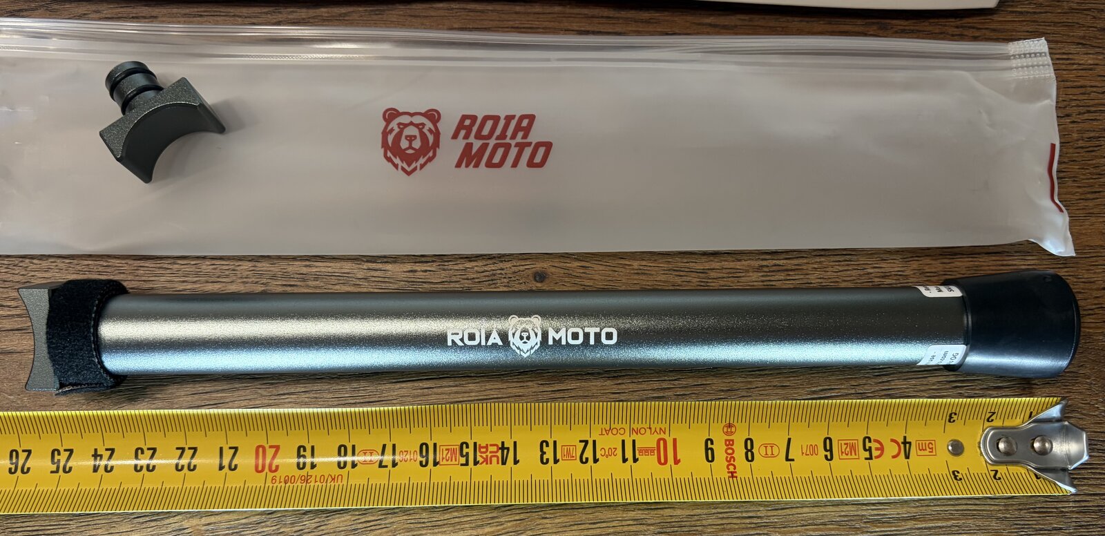 Roia Moto Trail Jack beside a tape measure, with its cradle and storage pouch
