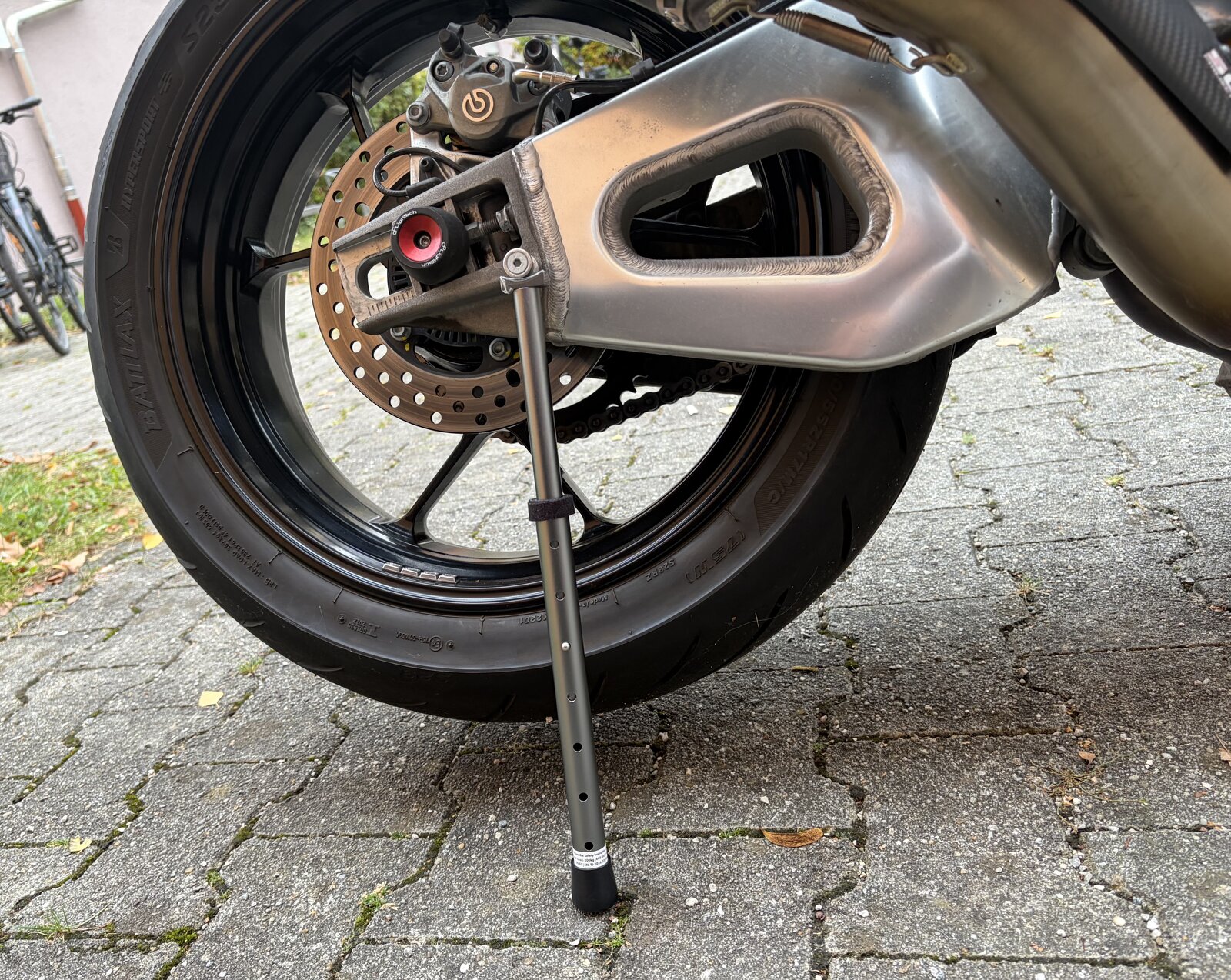 Close-up of the Roia Moto Trail Jack supporting the Aprilia Tuono V4 Factory 1100’s swingarm